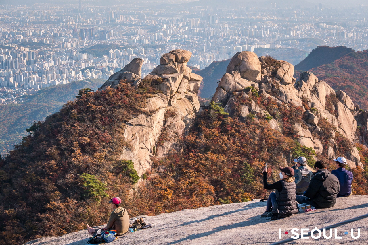 プッカンサン(北漢山)の頂上に座ってソウル市内を見下ろす人々