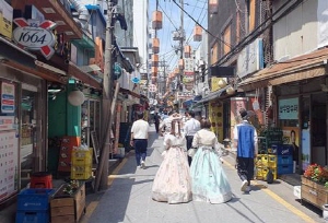 韓服を着た外国人が西村通りを歩いている写真