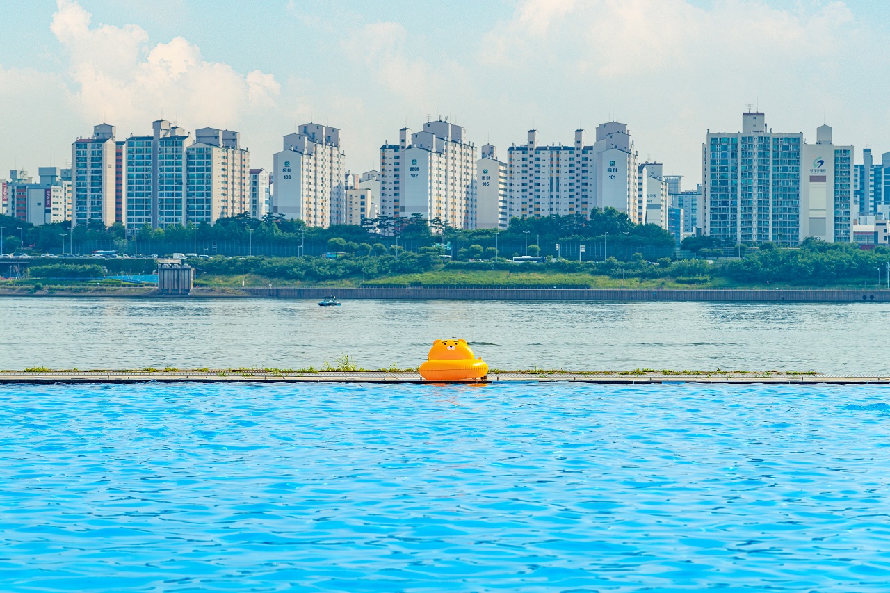 マンション団地を背景に黄色い浮き輪が浮いている蘭芝漢江公園の水遊び場の写真